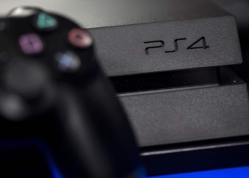 A logo sits on the front of a Sony PlayStation 4 (PS4) games console, manufactured by Sony Corp., in this arranged photograph taken in London, U.K., on Friday, Nov. 15, 2013. Sony, who released the PlayStation 4 game console today, is confident it can meet analysts' sales estimates of 3 million units by year-end, exploiting an early advantage over Microsoft Corp.'s Xbox One. Photographer: Simon Dawson/Bloomberg via Getty Images
